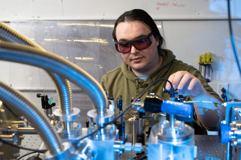 A student adjusts a laser in a physics laboratory.